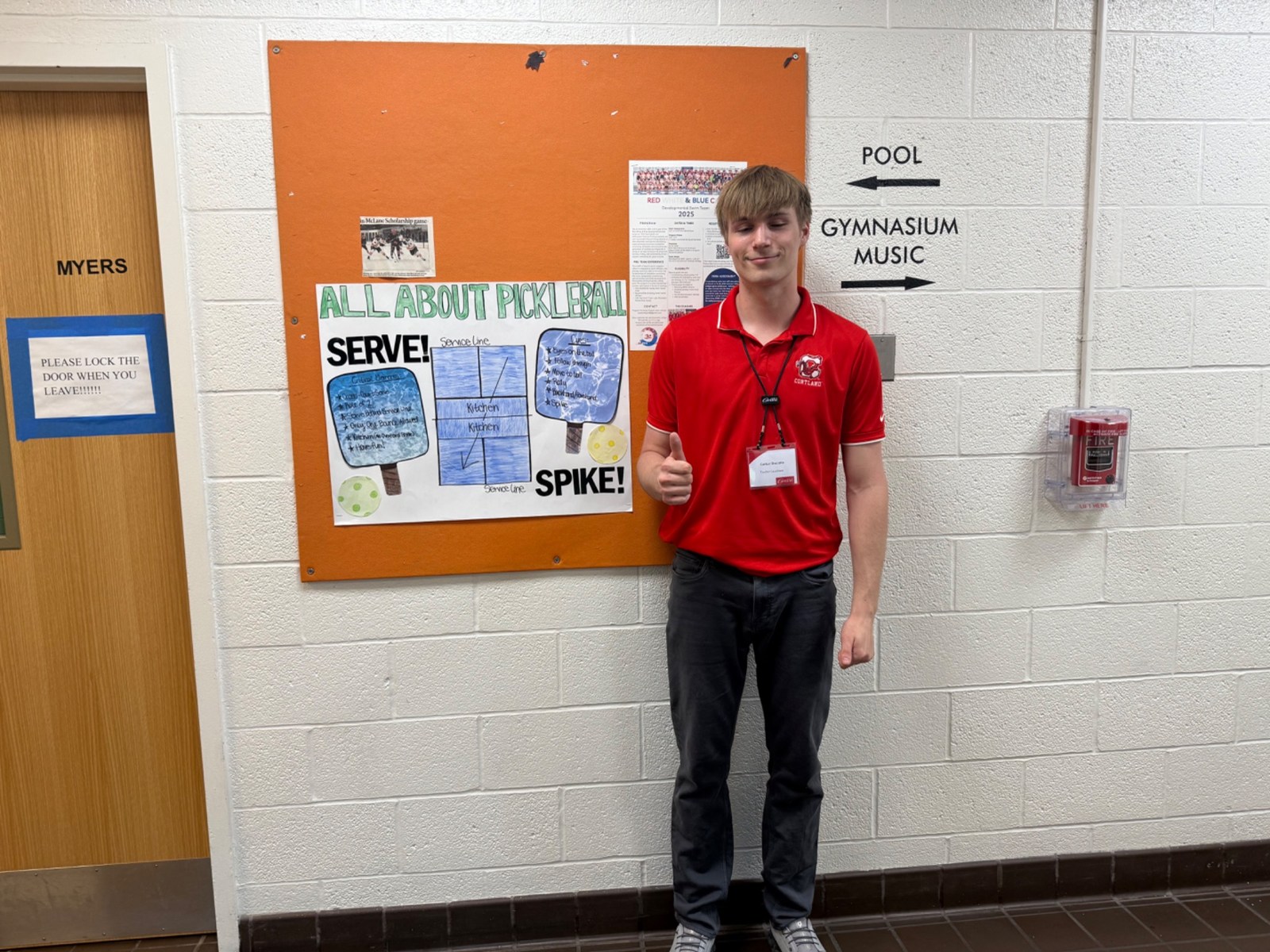 Carter beside an All About Pickleball display